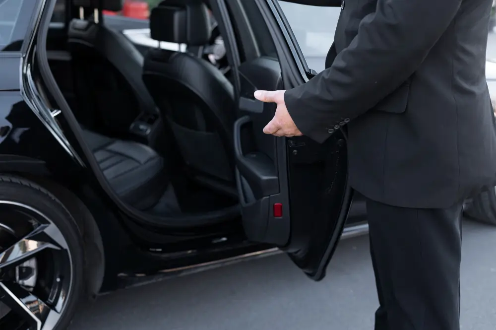 Chauffeur opening taxi door for Gatwick airport passenger