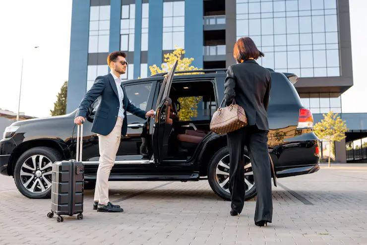 Travelers with luggage boarding Luton Airport taxi