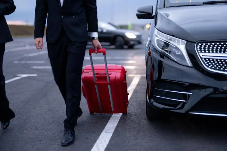 Business traveler with luggage near Gatwick airport taxi